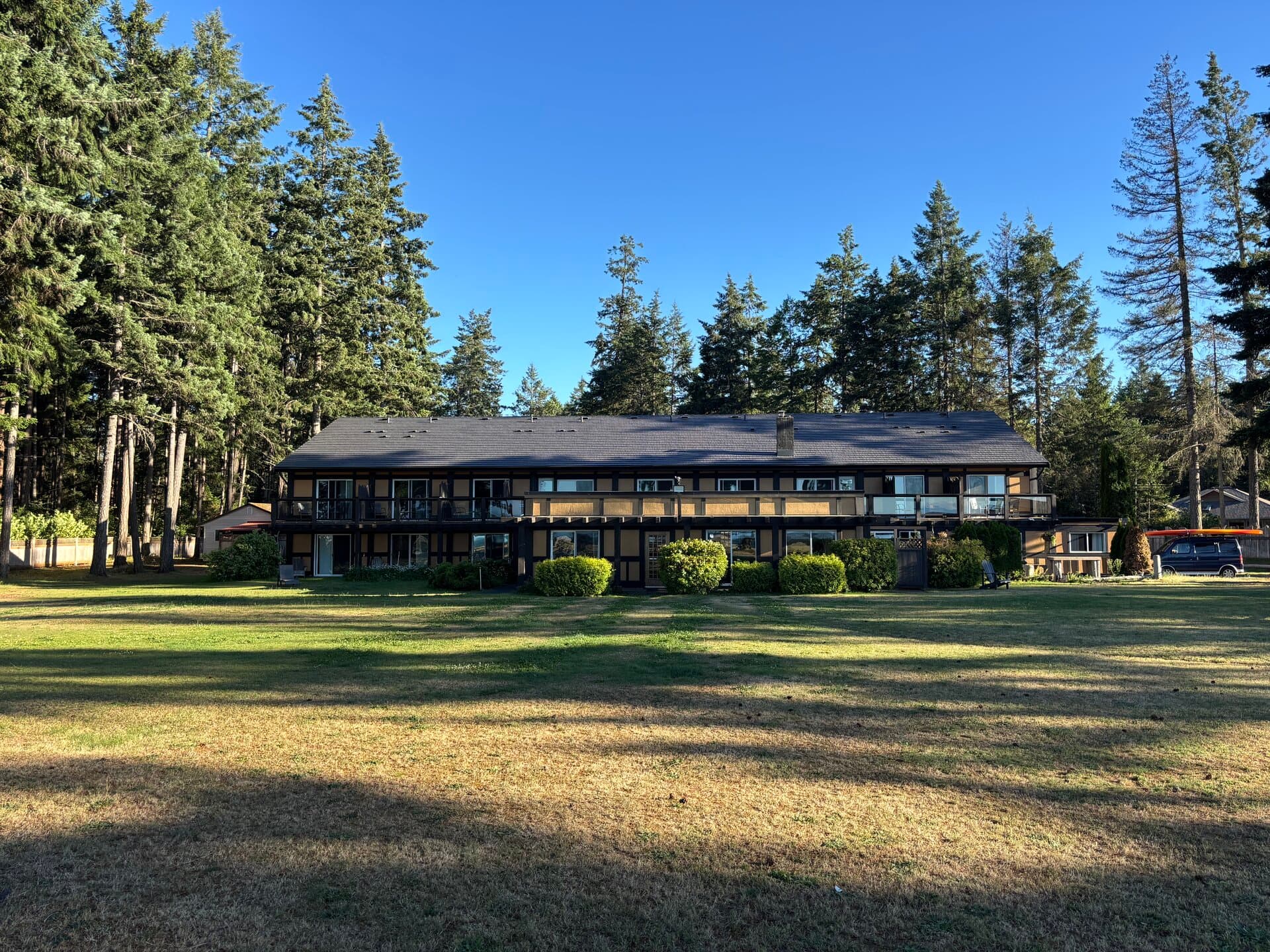 Two-story Tudor-style main building with balconies and lawn