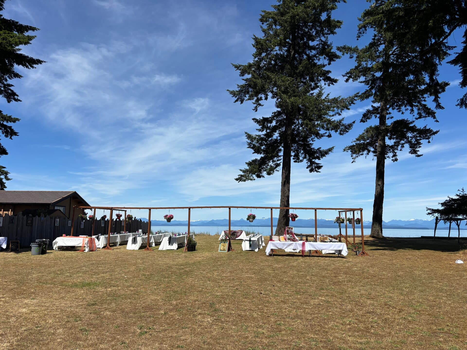 Outdoor banquet tables under a pergola overlooking the ocean