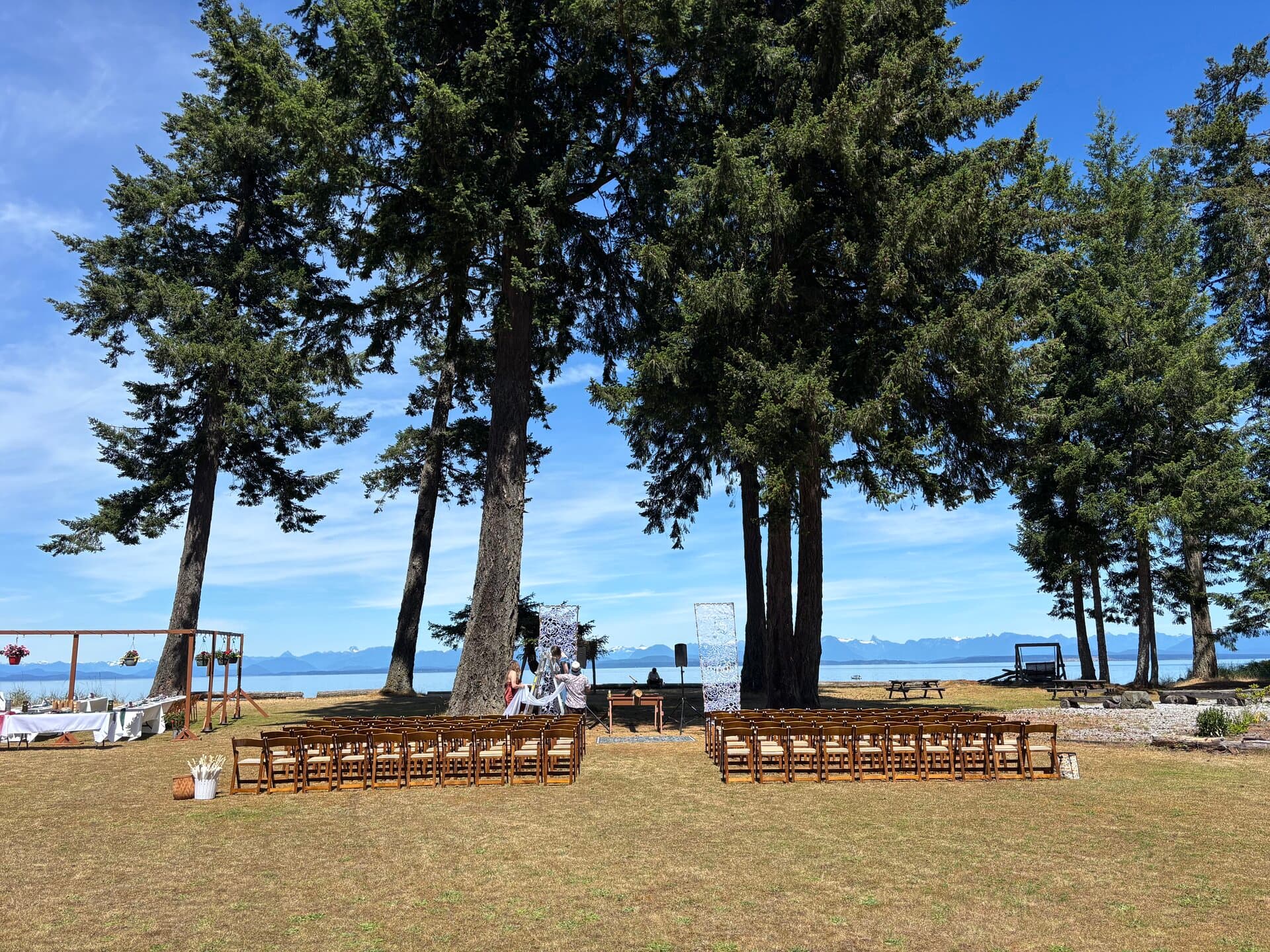 Outdoor wedding ceremony setup with ocean and mountain views