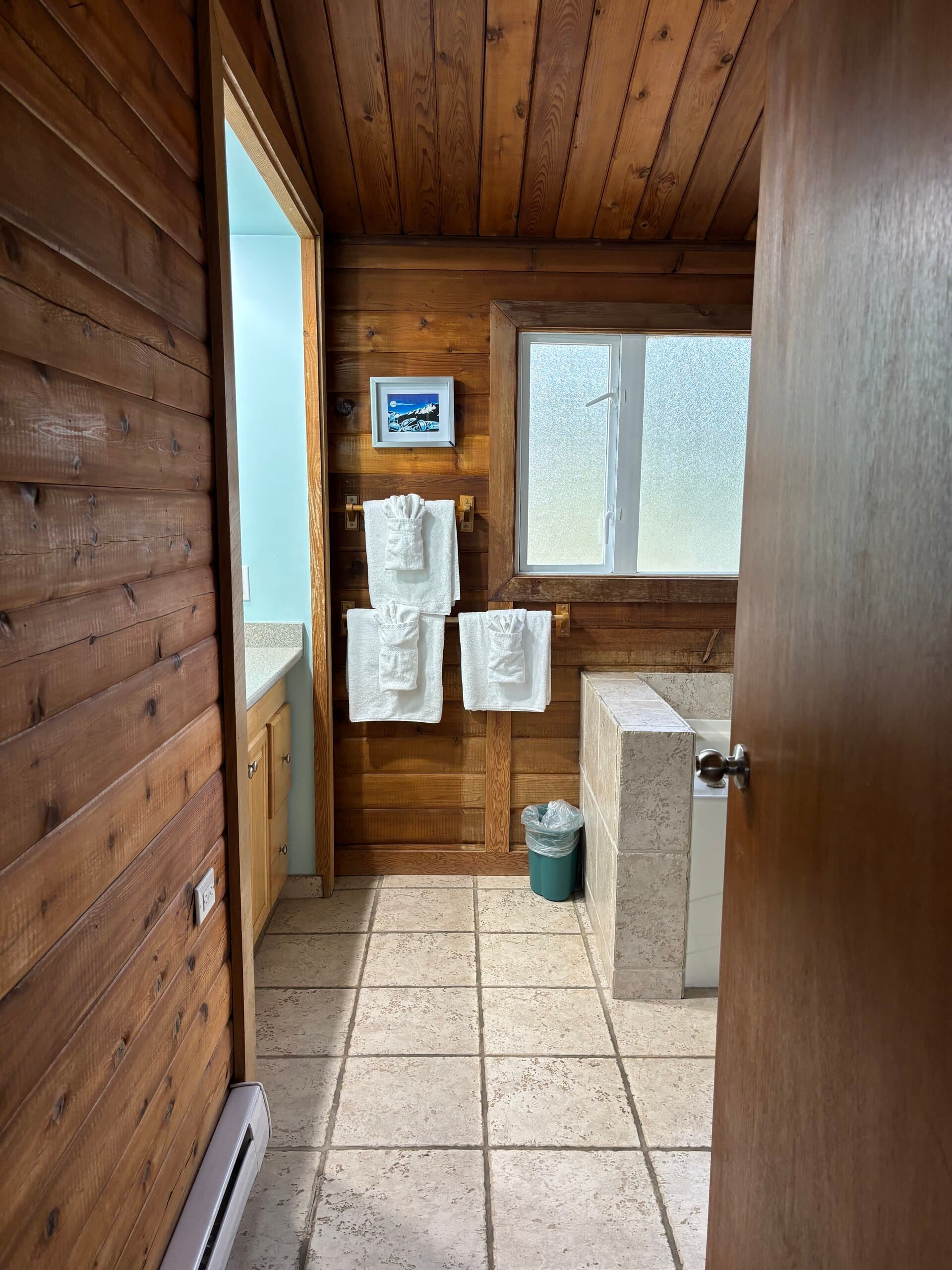 Wood-paneled bathroom with tub and shower enclosure