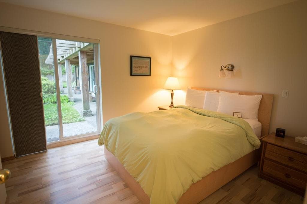 Separate queen bedroom with patio access and warm bedside lighting