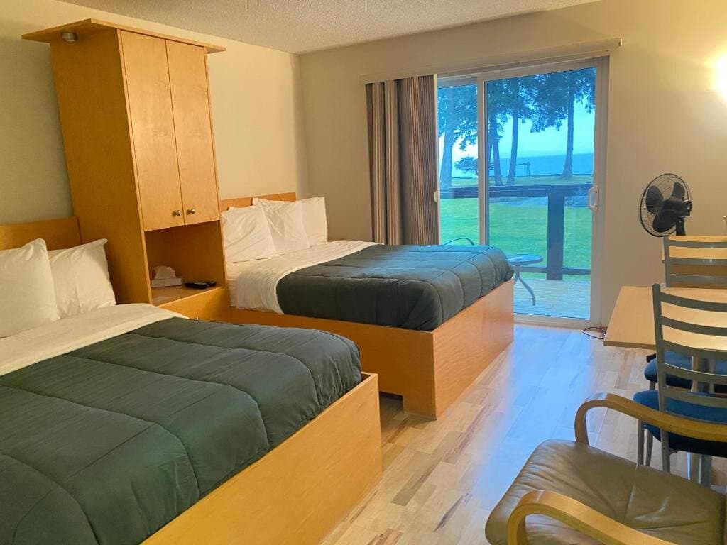 Double and twin beds with dining area and ocean-view sliding doors