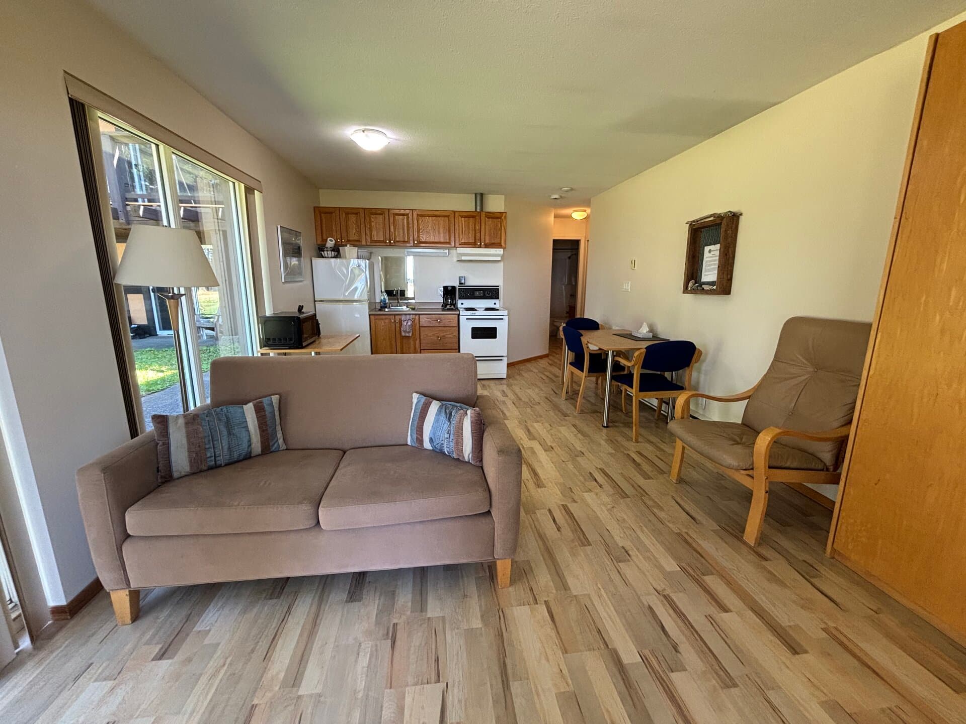 Queen suite living area with full kitchen, dining, and patio doors