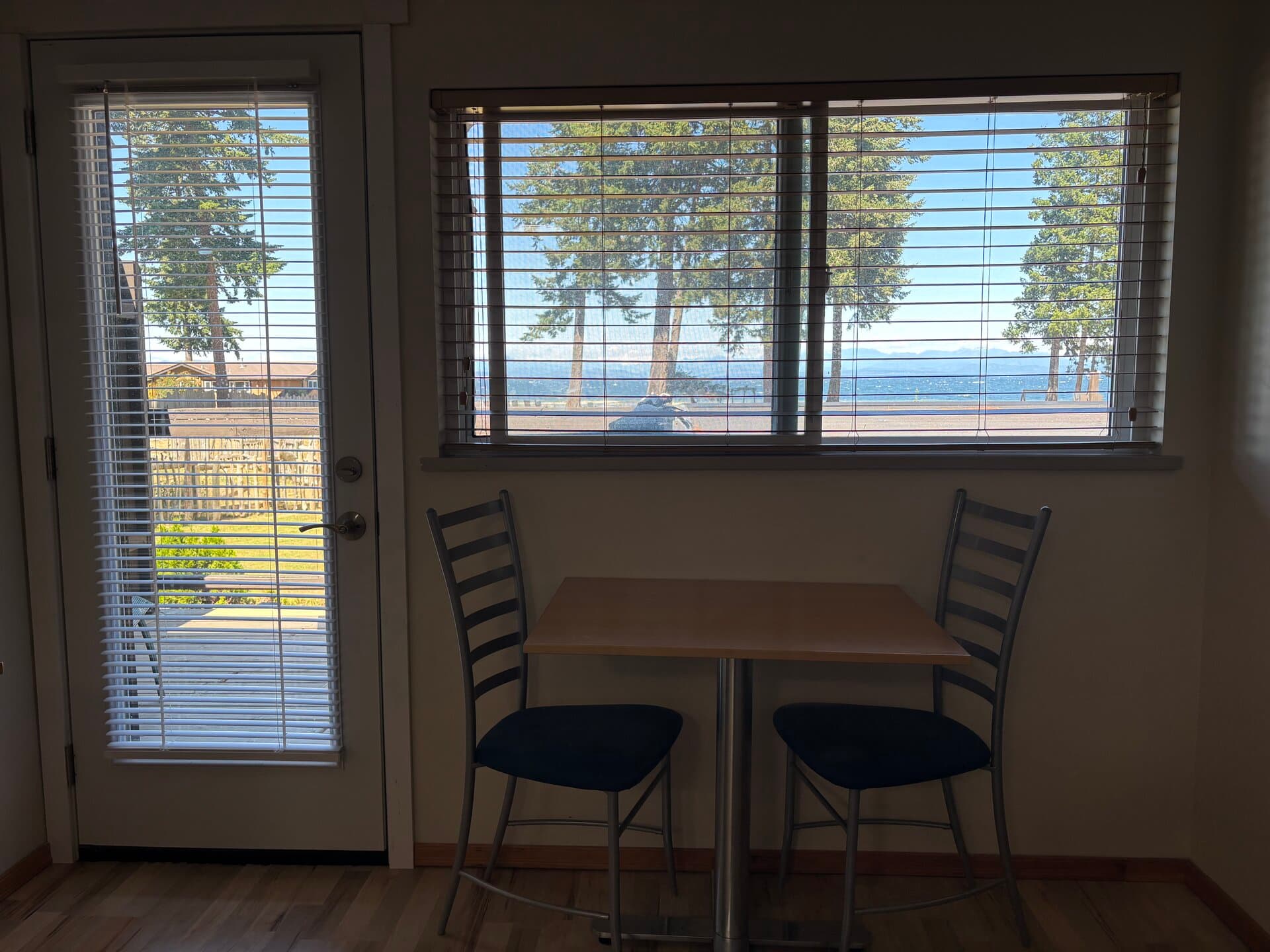 Dining table beside the balcony door and window with ocean views
