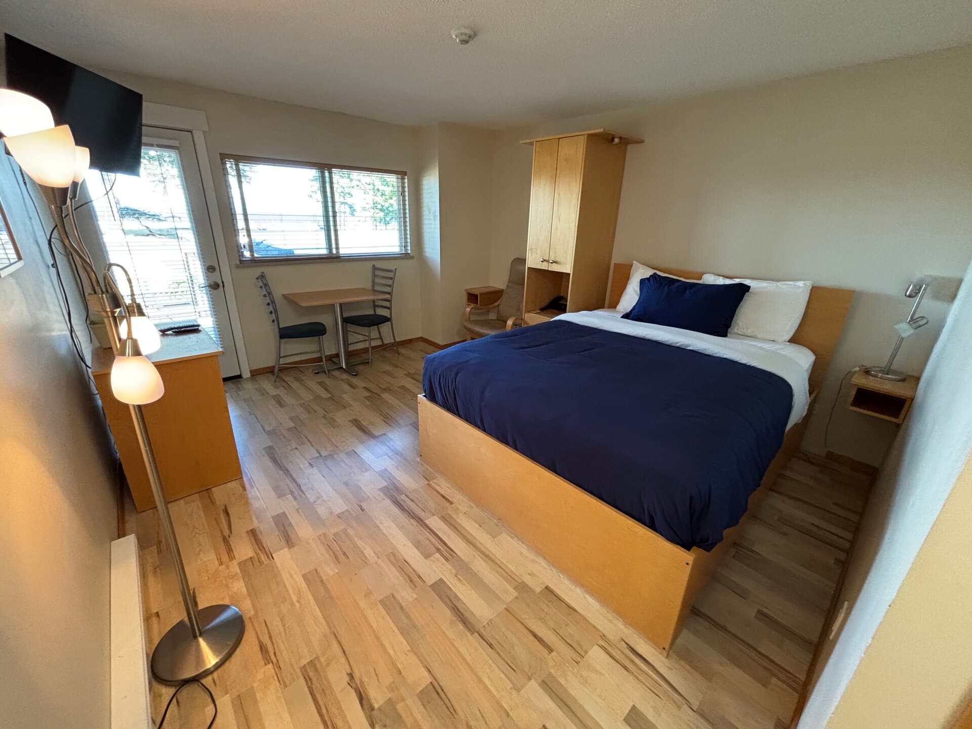 Deluxe Ocean View room with one queen bed, dining table, and coastal views