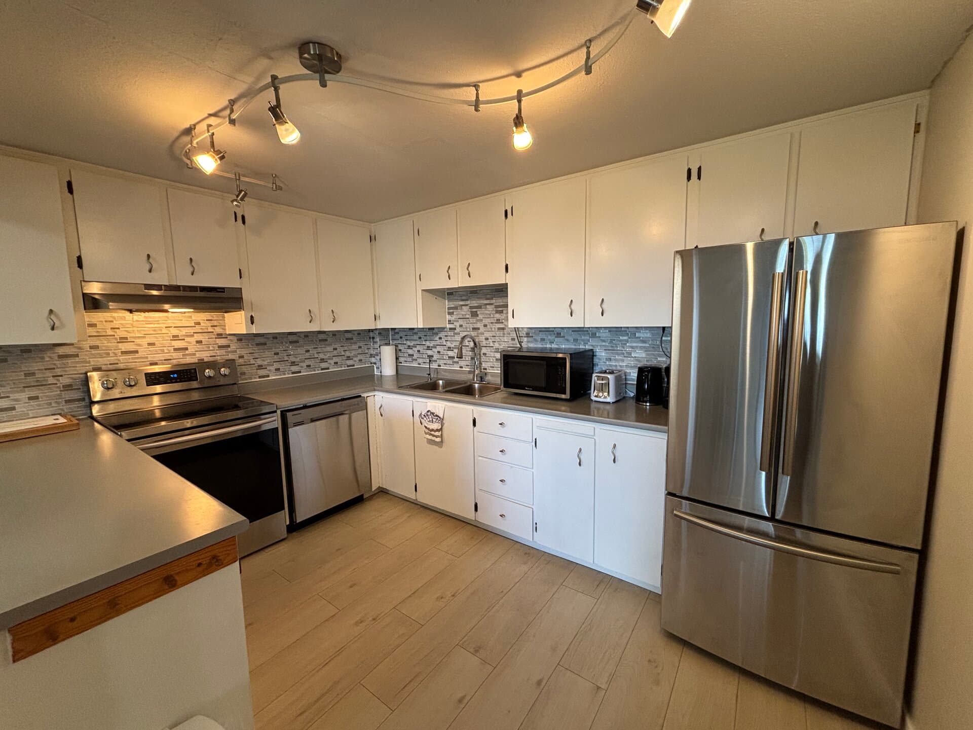 Full kitchen with stainless refrigerator, range, dishwasher, and microwave