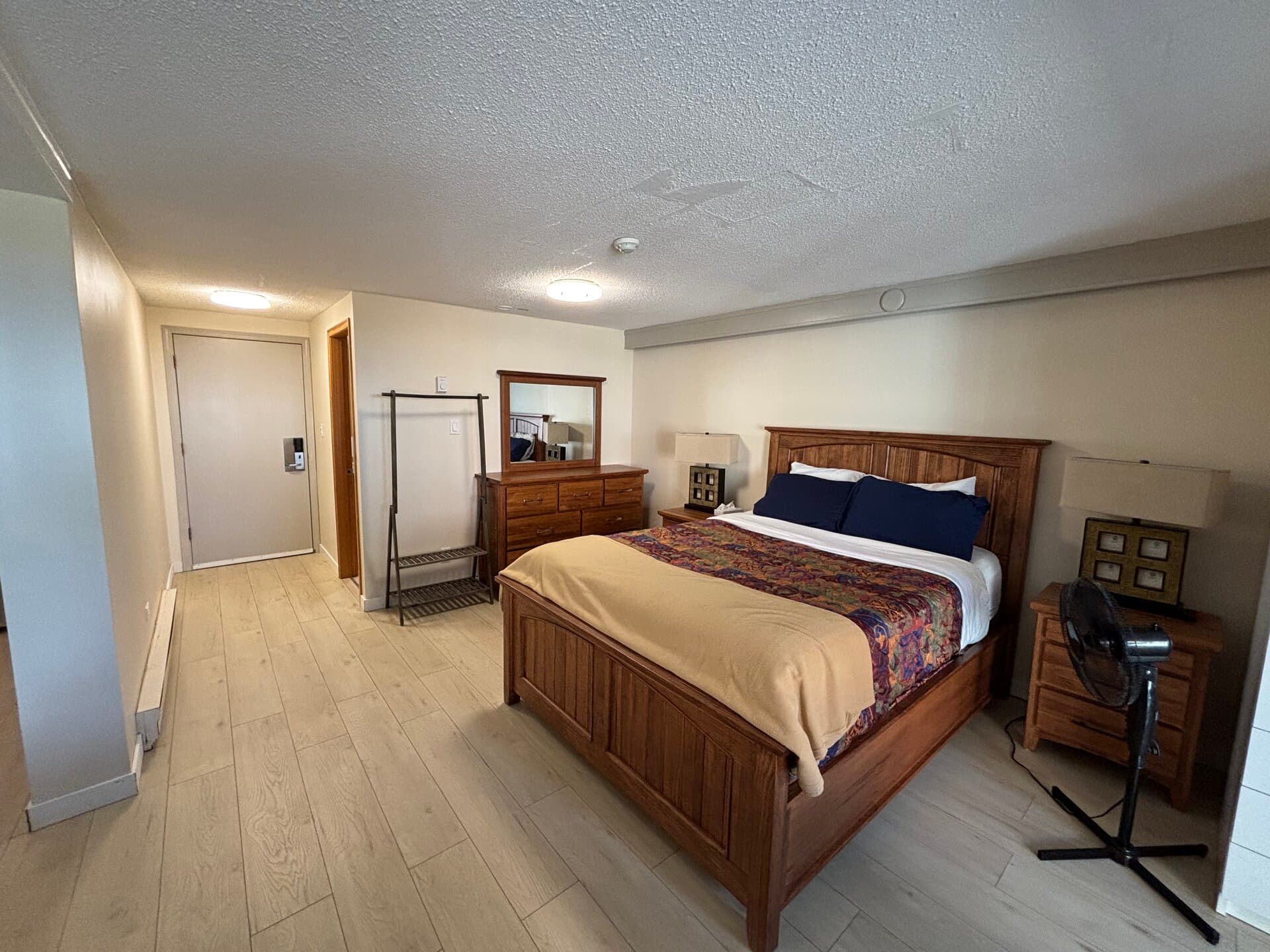 Queen bed with wood furniture, dresser, and bedside tables