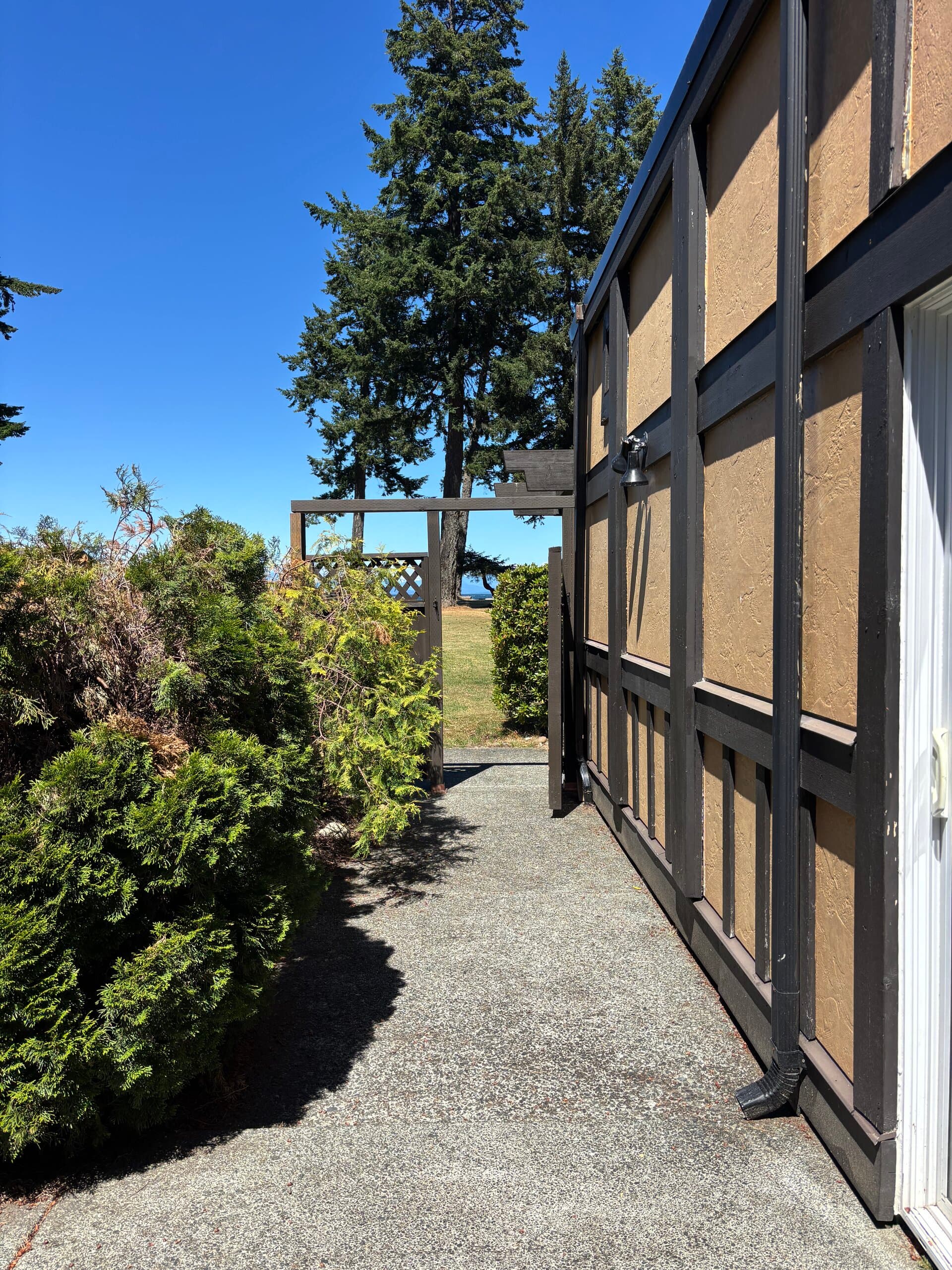 Landscaped walkway beside the suite with an ocean glimpse