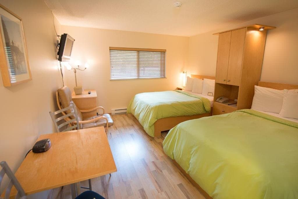 Economy Double Room beds with wardrobe, TV, and dining area
