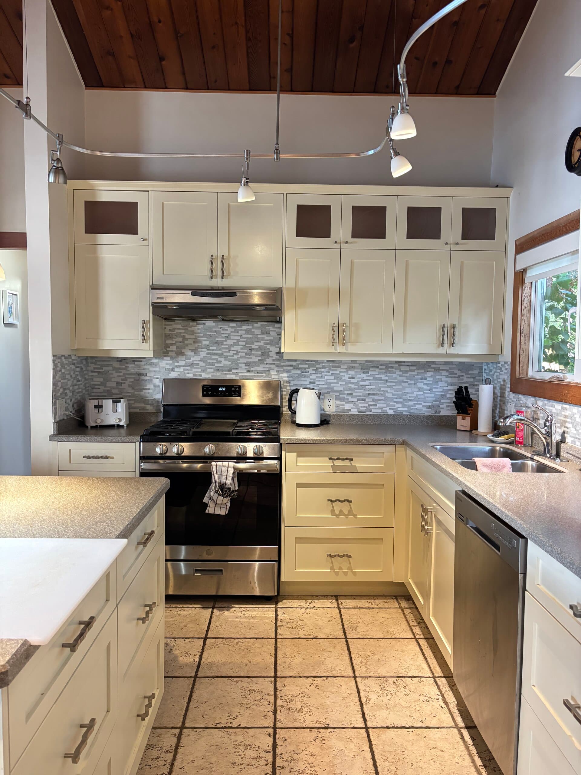 Full kitchen with gas range, cream cabinets, and island