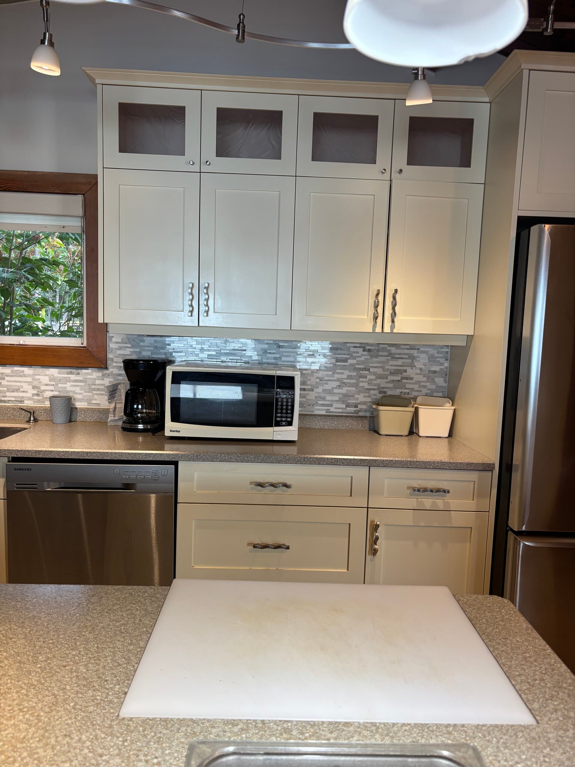 Kitchen counter with dishwasher, microwave, and coffee maker