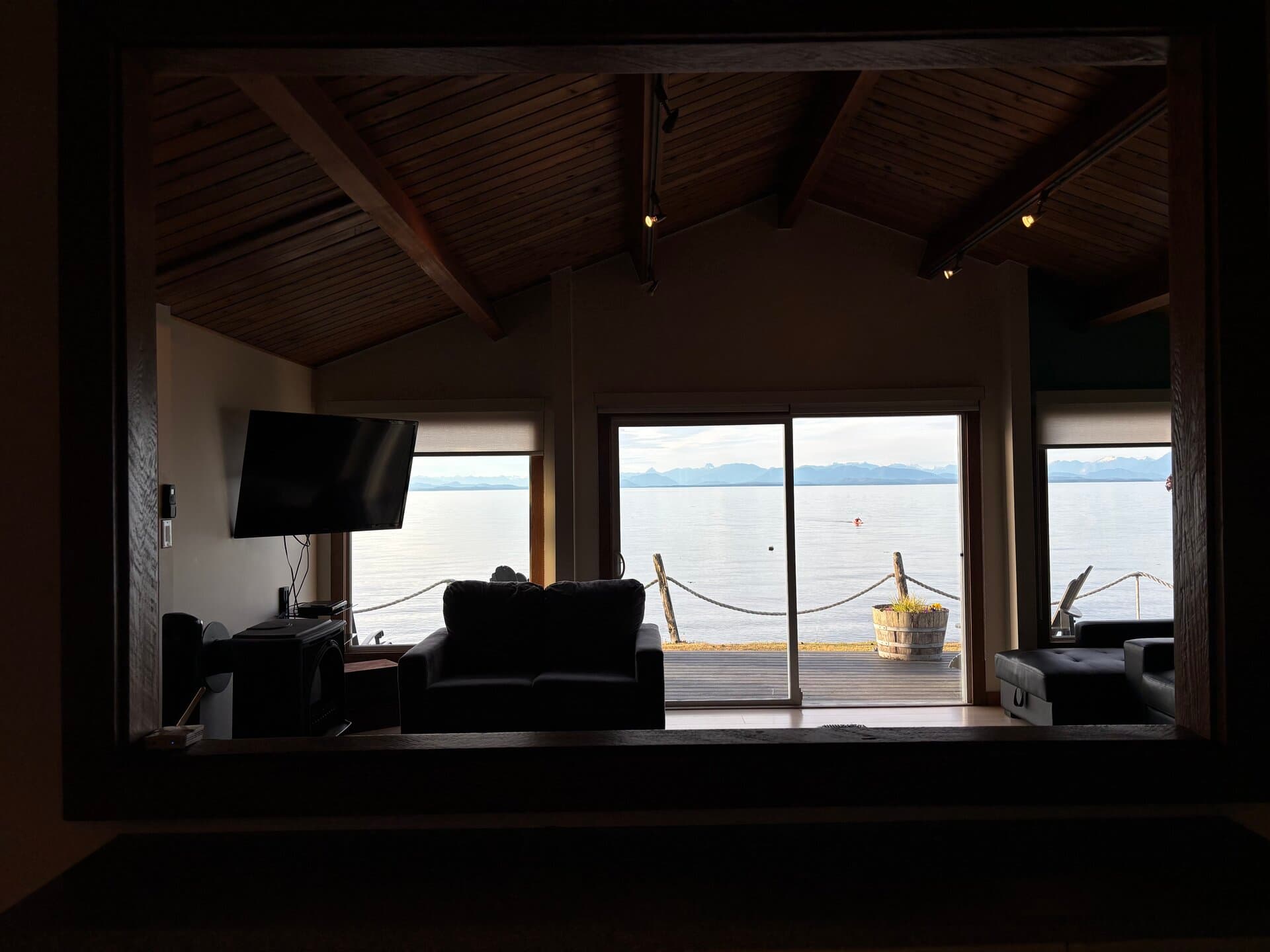 Living room through kitchen pass-through with fireplace and ocean view
