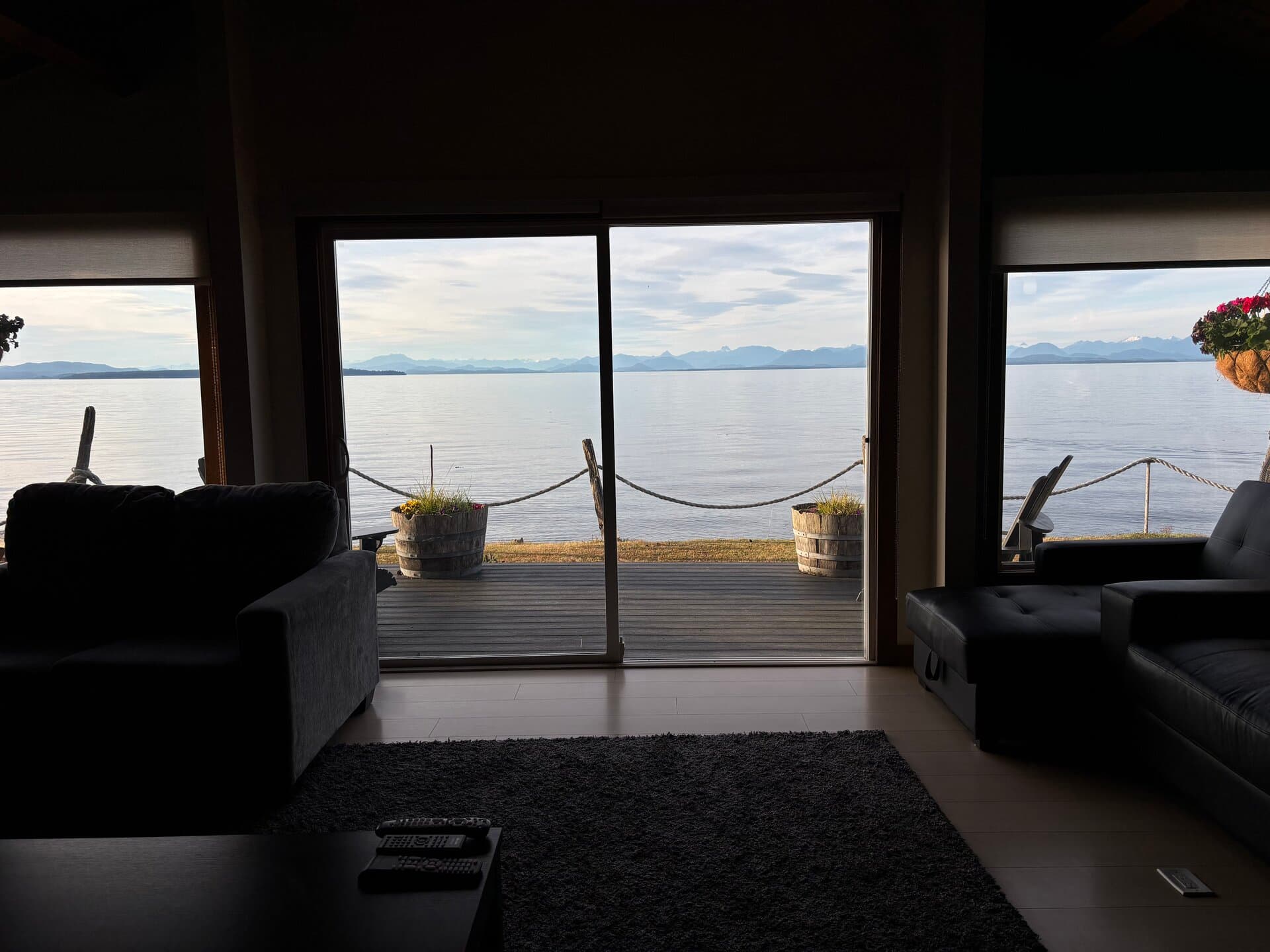 Living room sofas with deck and ocean views at dusk