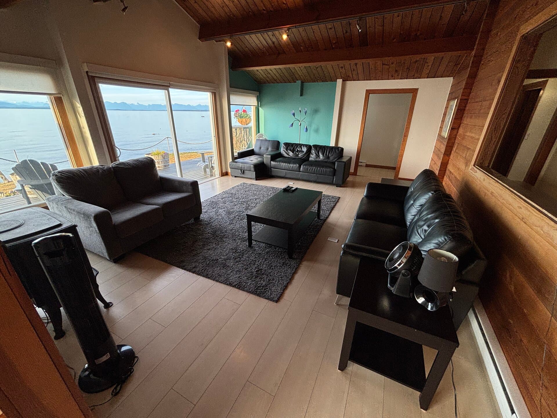Living room with teal accent wall and ocean-view deck