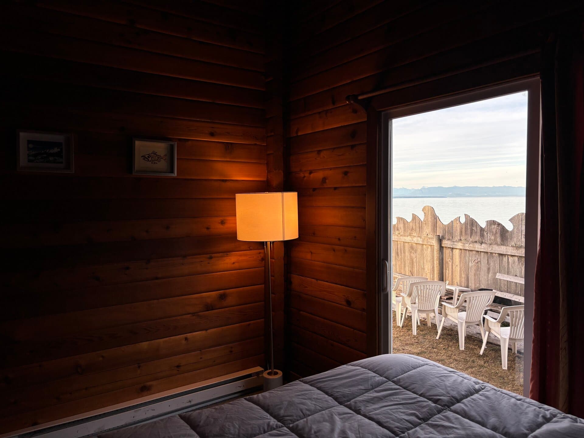 Rustic log-wall bedroom with ocean views through sliding doors