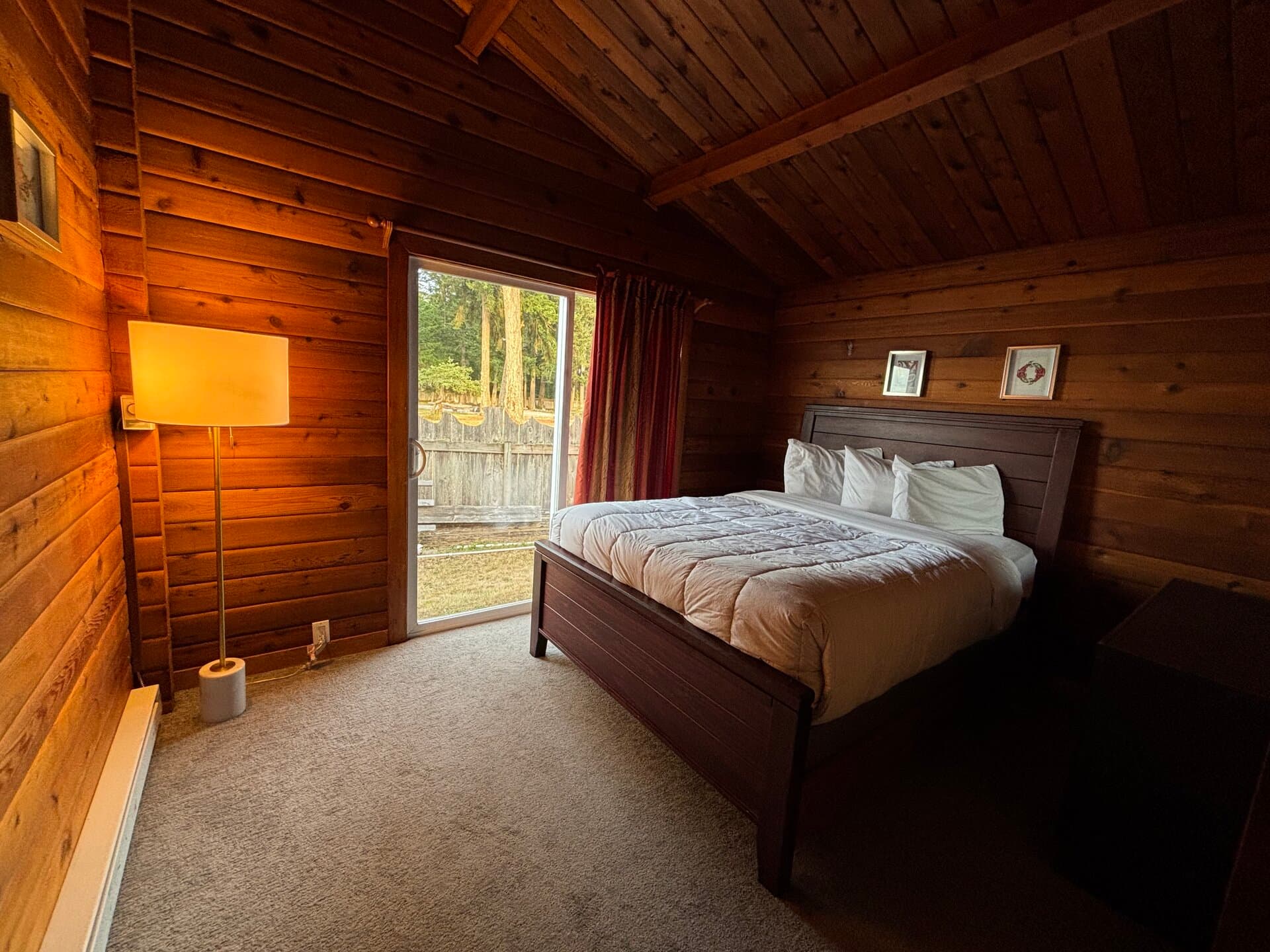 Rustic log-wall queen bedroom with garden views