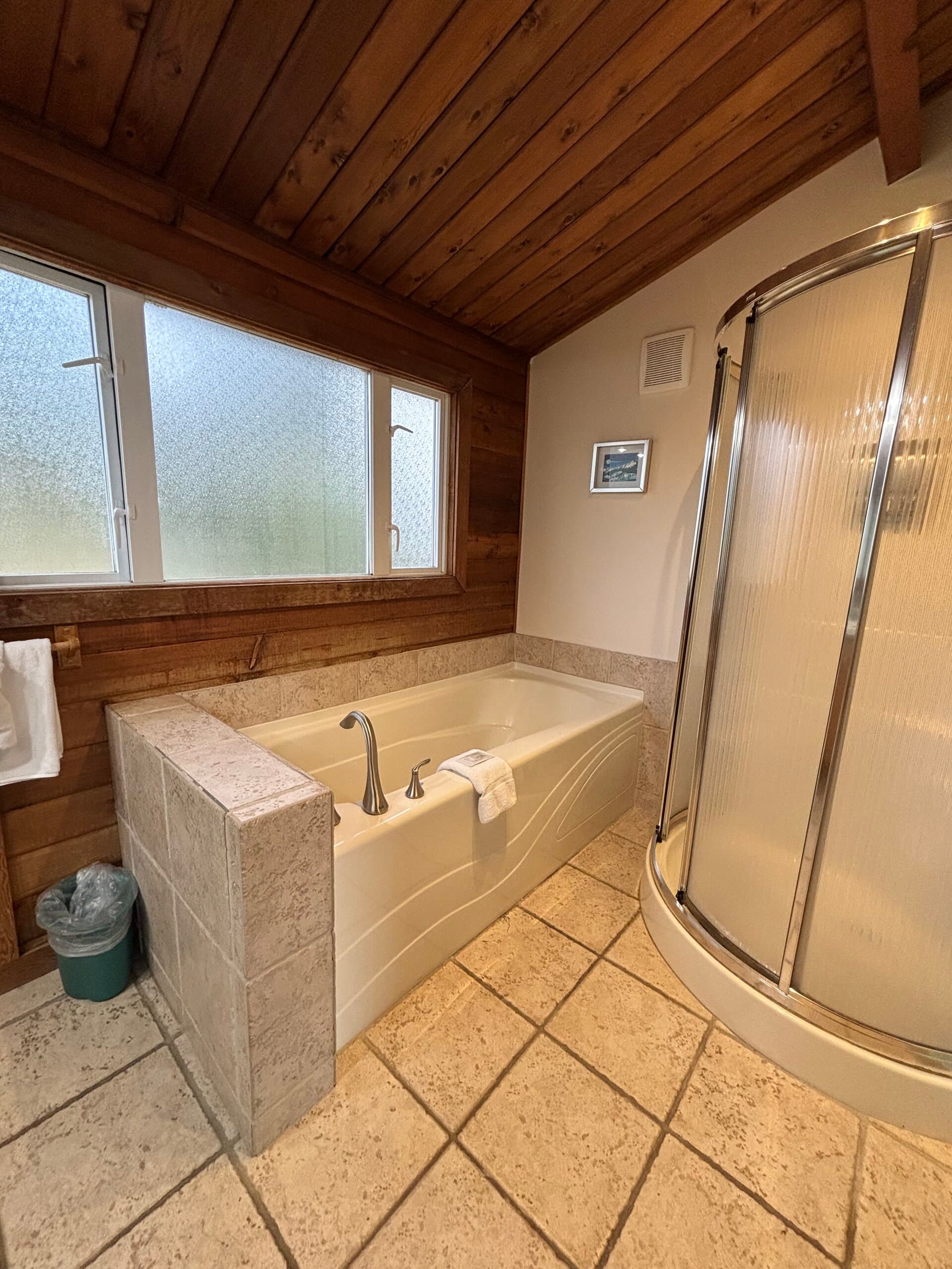 Spa bathroom with soaking tub, walk-in shower, and wood ceiling