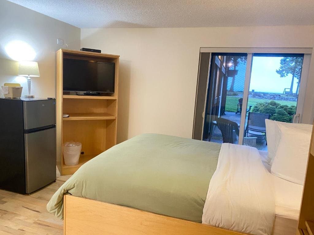 Ground-floor queen room with patio chairs and ocean views