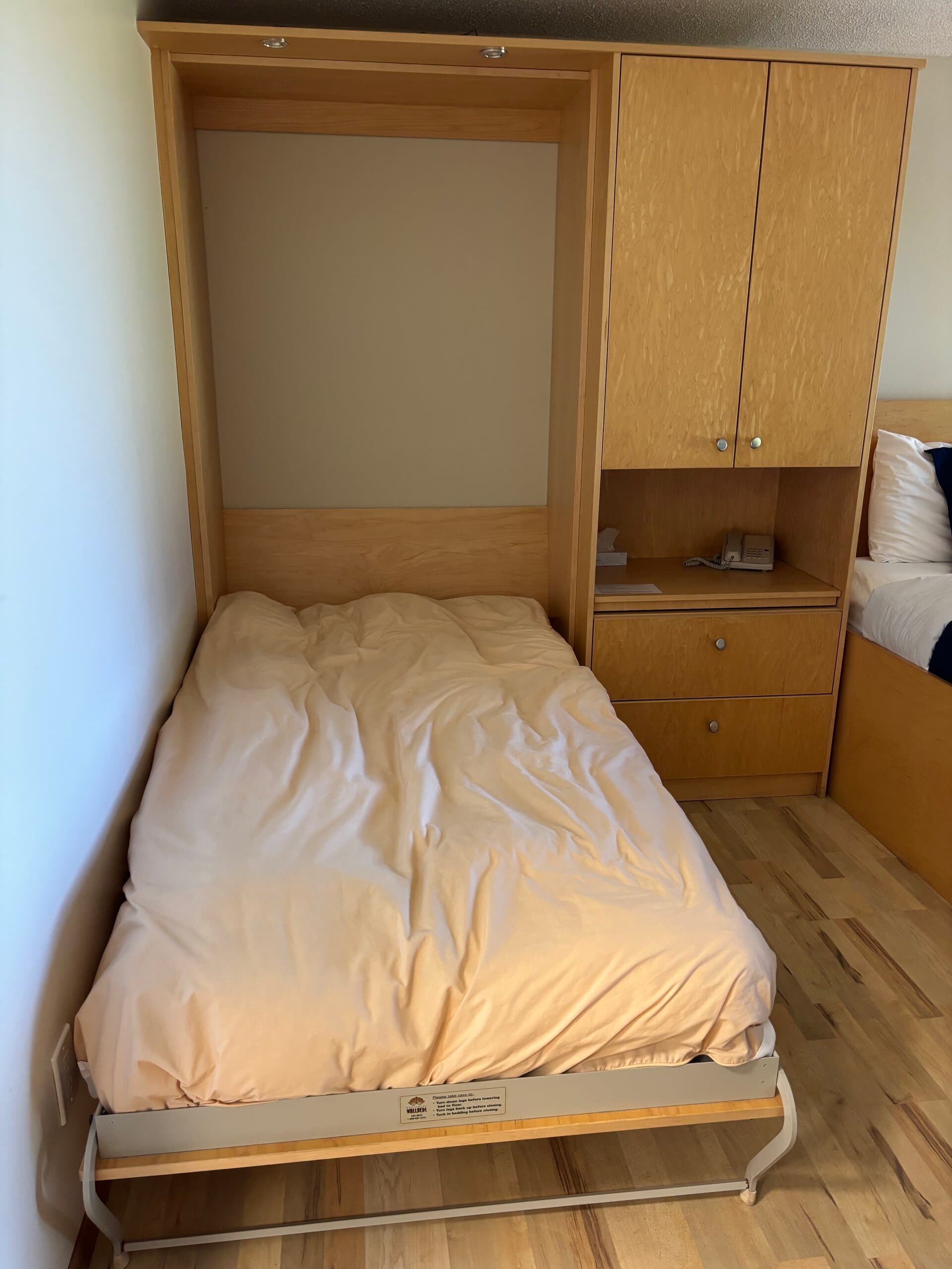 Murphy bed lowered with bedside phone and nightstand