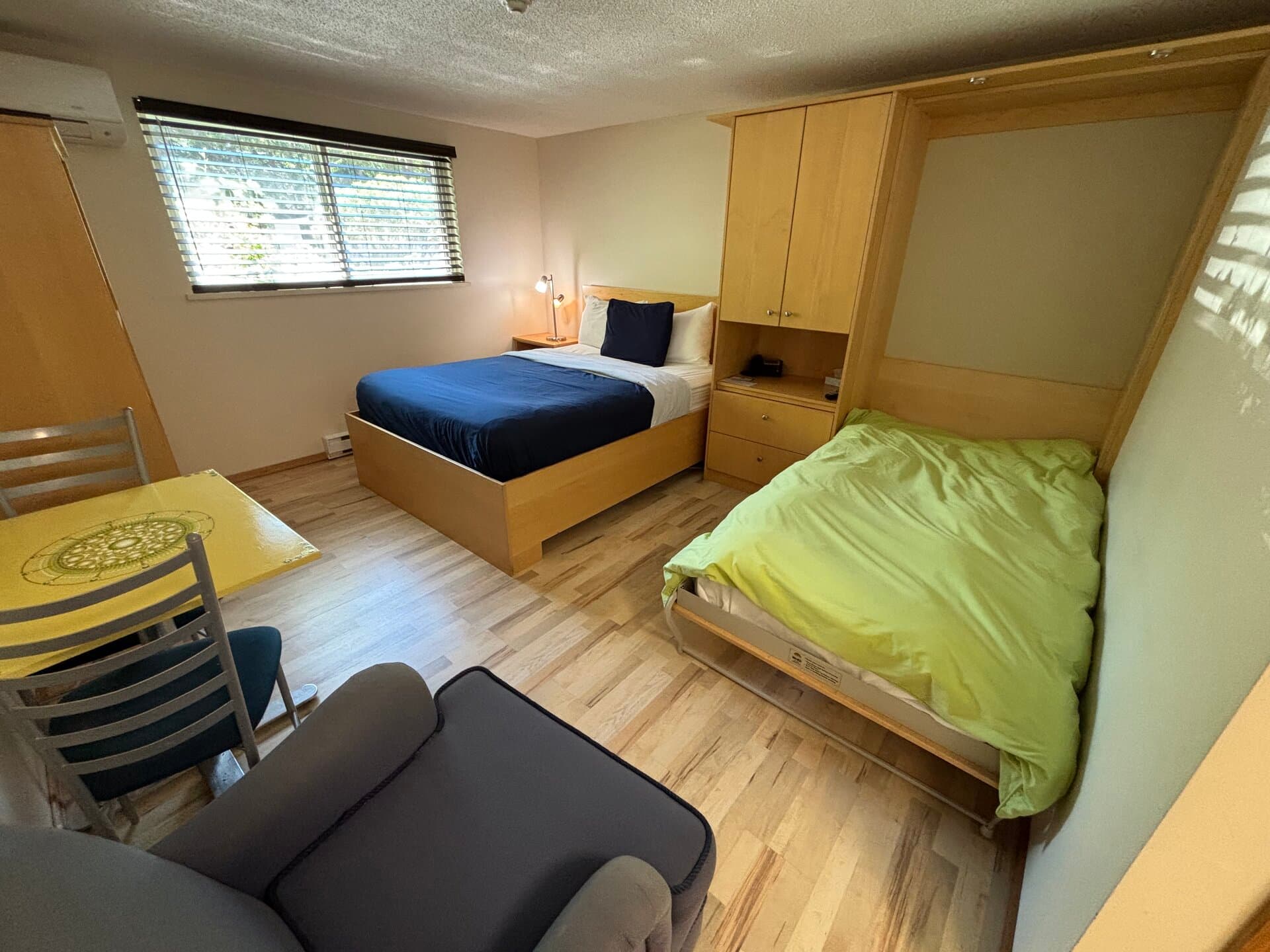 Murphy bed lowered beside the queen bed with dining area