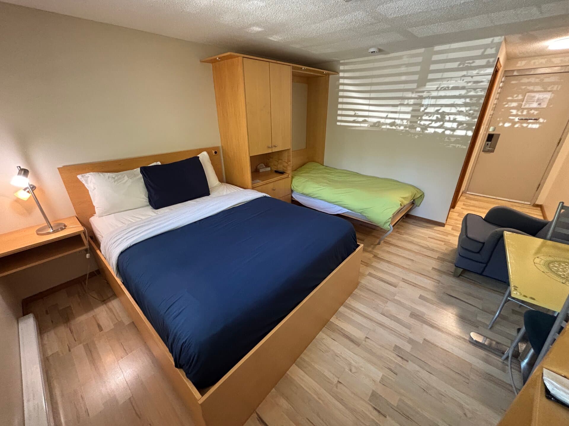 Queen bed with adjoining twin bed and yellow dining table