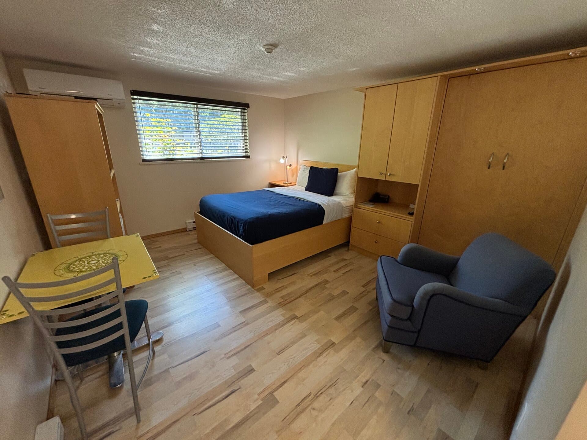 Queen bed with Murphy cabinet, dining area, and courtyard views