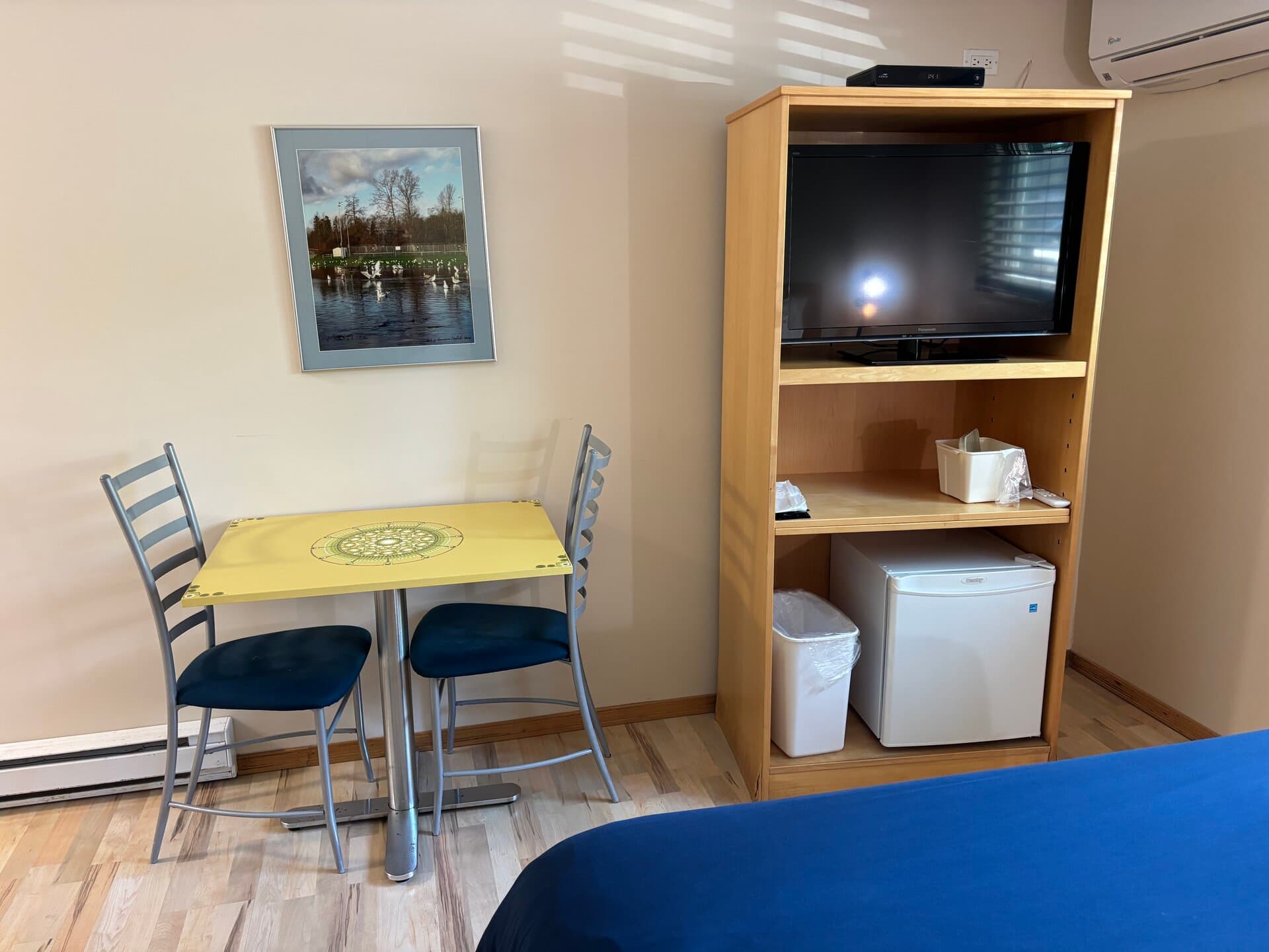 Dining table, TV, mini-fridge tower, and air conditioning