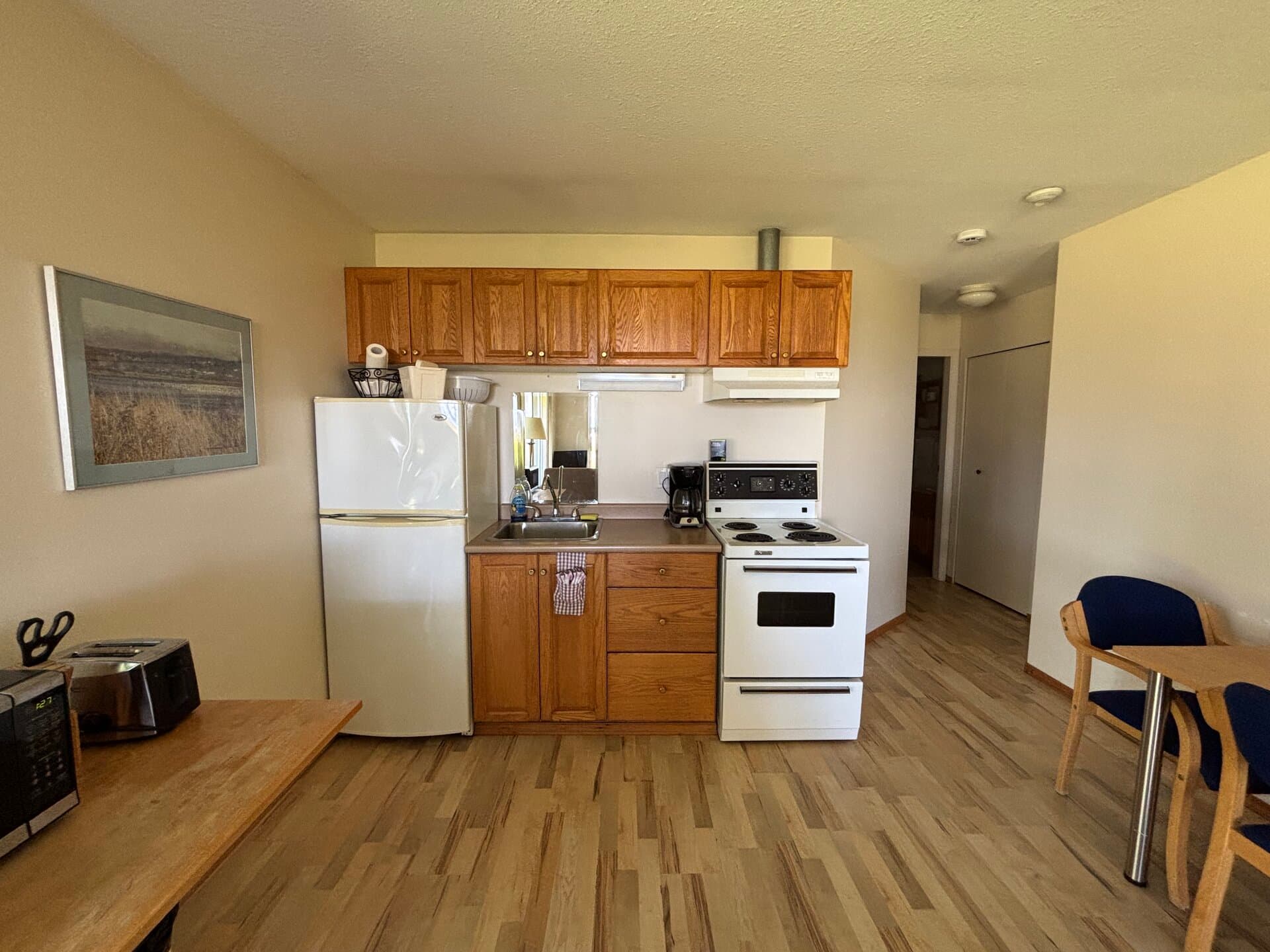 Kitchenette with refrigerator, range, sink, and dining table