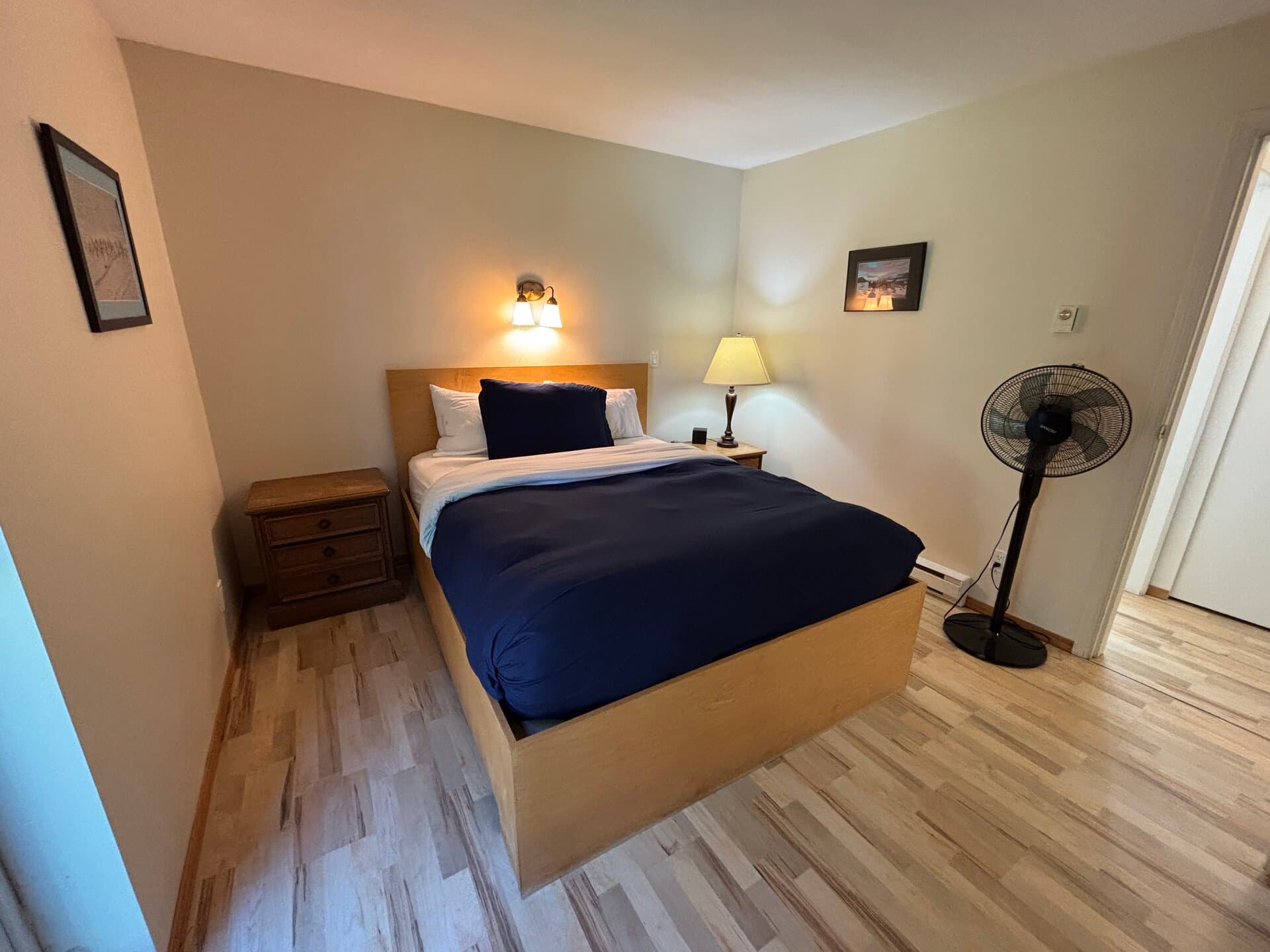 Queen bedroom with wood bed frame and nightstands