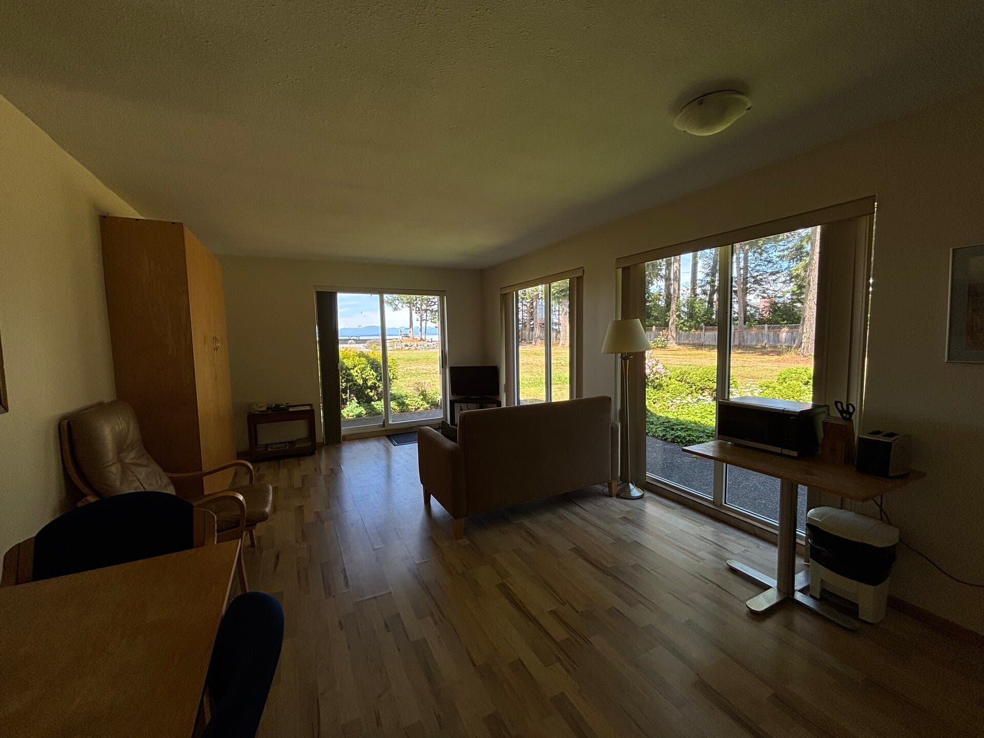Living area with sofa, kitchenette, and ocean views through patio doors