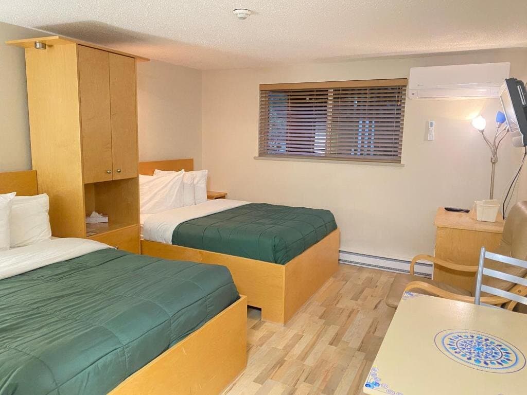 Economy Double Room with two double beds, dining table, and mini-fridge